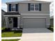 Two-story home featuring a neutral gray exterior, a two-car garage, and dark blue shutters on the windows at 8646 Sw 44Th Ter, Ocala, FL 34476