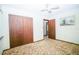Cozy bedroom featuring brown carpet, closet, ceiling fan, and neutral walls at 3990 Se 20Th Ct, Ocala, FL 34480