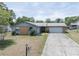 Charming single-story home with a well-manicured lawn and a long driveway leading to an attached garage at 3990 Se 20Th Ct, Ocala, FL 34480