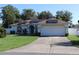 Charming single-story home with a well-manicured lawn and solar panels on the roof at 4413 Sw 145Th Place Rd, Ocala, FL 34473