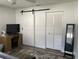 Bedroom featuring wood-look floors, a sliding barn door, and a neutral color palette at 8533 Sw 93Rd Pl # A, Ocala, FL 34481