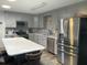 Updated kitchen featuring gray cabinetry, stainless appliances, stone backsplash, and a large center island at 8533 Sw 93Rd Pl # A, Ocala, FL 34481