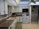Traditional kitchen with white cabinets, an oven, and a view to an adjacent room at 8665 Sw 94Th St # C, Ocala, FL 34481