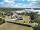 Beautiful aerial view of the property with lush landscaping and a picturesque lake in the background at 11395 Se 108Th Terrace Rd, Belleview, FL 34420