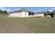 Grassy backyard featuring an enclosed porch, well-maintained lawn, and mature trees for privacy and shade at 11395 Se 108Th Terrace Rd, Belleview, FL 34420