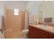 Bathroom featuring a walk-in shower with tile walls and flooring and vanity with wood cabinets at 11395 Se 108Th Terrace Rd, Belleview, FL 34420