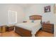 Relaxing bedroom featuring a wooden bed frame, matching nightstands, and warm natural light at 11395 Se 108Th Terrace Rd, Belleview, FL 34420