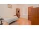 Cozy bedroom featuring warm hardwood floors, vintage wood wardrobe, and a comfortable bed setting at 11395 Se 108Th Terrace Rd, Belleview, FL 34420
