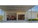 Exterior view of the home's expansive garage space and covered storage area with metal roof at 11395 Se 108Th Terrace Rd, Belleview, FL 34420