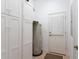 Utility room featuring white cabinets, water heater, and access door at 11395 Se 108Th Terrace Rd, Belleview, FL 34420