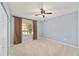 Bedroom features a ceiling fan, closet and window with curtains at 11427 Sw 82Nd Ave, Ocala, FL 34481