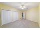 Bright bedroom featuring neutral carpet and ceiling fan plus double door closets at 11427 Sw 82Nd Ave, Ocala, FL 34481