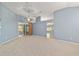 Bright living room with neutral carpet, ceiling fan, and sliding door access to the patio at 11427 Sw 82Nd Ave, Ocala, FL 34481