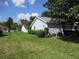 Side view of the home featuring a lush green lawn and mature landscaping at 11495 Sw 138Th Ln, Dunnellon, FL 34432