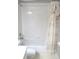 This bathroom has a white tiled shower-tub combo with decorative shower curtain at 11495 Sw 138Th Ln, Dunnellon, FL 34432