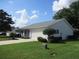 Exterior of the home showing the two car garage, lawn, and landscaping at 11495 Sw 138Th Ln, Dunnellon, FL 34432