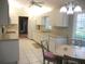 Eat-in kitchen featuring white cabinets, modern appliances, and tile flooring at 11495 Sw 138Th Ln, Dunnellon, FL 34432