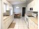 Updated kitchen features white cabinetry, modern appliances, and tile floors at 11495 Sw 138Th Ln, Dunnellon, FL 34432