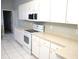 The bright kitchen has white cabinetry, appliances, and a long counter with views to the dining table at 11495 Sw 138Th Ln, Dunnellon, FL 34432