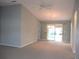 Spacious living room featuring vaulted ceiling and sliding door access to outdoor patio at 11495 Sw 138Th Ln, Dunnellon, FL 34432