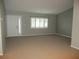 Bright living room features a large window, neutral paint, and plush carpet at 11495 Sw 138Th Ln, Dunnellon, FL 34432