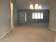 Inviting living room with natural light, carpet, neutral paint, and front door view at 11495 Sw 138Th Ln, Dunnellon, FL 34432