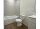 Bright bathroom with tile surround bathtub and shower, and stylish wood-look tile floor at 11555 Sw 59Th Ter, Ocala, FL 34476