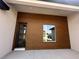 Up close view of the home's front entrance, with a contemporary door and wood-paneled wall at 11555 Sw 59Th Ter, Ocala, FL 34476