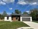 A welcoming single-story home boasts a gray roof, a one-car garage, and fresh green lawn at 11555 Sw 59Th Ter, Ocala, FL 34476