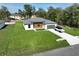 Aerial view of a modern home featuring a well-maintained lawn and a car parked in the long driveway at 11555 Sw 59Th Ter, Ocala, FL 34476