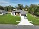 Aerial view of a modern home with a well-maintained lawn, long driveway, and a car parked in front at 11555 Sw 59Th Ter, Ocala, FL 34476