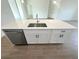 Stylish kitchen island with a stainless steel sink, modern faucet, and sleek cabinetry at 11555 Sw 59Th Ter, Ocala, FL 34476