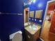 Bathroom with blue walls, vanity, mirror, and tile flooring at 15115 Se 94Th Ct, Summerfield, FL 34491
