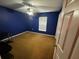 This bedroom features blue walls, carpeted floors, and a ceiling fan, creating a comfortable and inviting space at 15115 Se 94Th Ct, Summerfield, FL 34491