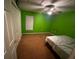 This bedroom features green walls, carpeted floors, and a ceiling fan, creating a comfortable and inviting space at 15115 Se 94Th Ct, Summerfield, FL 34491