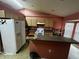 Functional kitchen with wooden cabinets, appliances and a breakfast bar island, perfect for casual dining at 15115 Se 94Th Ct, Summerfield, FL 34491
