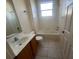 Cozy bathroom featuring a shower-tub combo, wooden vanity, and tiled flooring at 1703 Sanderling St, The Villages, FL 32162