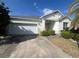 Inviting single-Gathering home features a well-maintained lawn and a convenient two-car garage at 1703 Sanderling St, The Villages, FL 32162