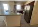 This kitchen features stainless steel appliances, tile floors, and an island with seating at 1703 Sanderling St, The Villages, FL 32162