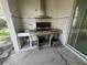 Covered patio area with built-in grill, perfect for outdoor entertaining at 1703 Sanderling St, The Villages, FL 32162