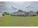 Wide backyard view with trimmed bushes lining the side of the house at 17475 Se 107Th Ct, Summerfield, FL 34491