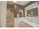 This bathroom features a white vanity with marble countertop and a shower-tub combo at 17475 Se 107Th Ct, Summerfield, FL 34491