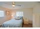 This bedroom features wood floors, a ceiling fan, and dual windows for natural light at 17475 Se 107Th Ct, Summerfield, FL 34491