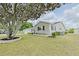 Well-manicured lawn complements the cozy home with a large, mature tree at 17475 Se 107Th Ct, Summerfield, FL 34491
