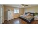 Cozy main bedroom with hardwood floors, large window, and a ceiling fan at 17475 Se 107Th Ct, Summerfield, FL 34491