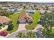 Aerial view of a well-maintained home with manicured lawns in a peaceful neighborhood with lush trees at 17645 Se 117Th Cir, Summerfield, FL 34491