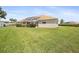 Manicured backyard with lush green grass, mature landscaping, and a screened-in lanai at 17645 Se 117Th Cir, Summerfield, FL 34491