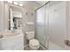 A well-lit bathroom featuring a vanity, toilet, and a shower with a sliding glass door at 17645 Se 117Th Cir, Summerfield, FL 34491