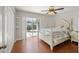 Bright bedroom boasts sliding glass doors leading to the outdoor patio and wood flooring at 17645 Se 117Th Cir, Summerfield, FL 34491