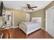 Serene bedroom featuring wood floors, ceiling fan, and en-suite bathroom access at 17645 Se 117Th Cir, Summerfield, FL 34491